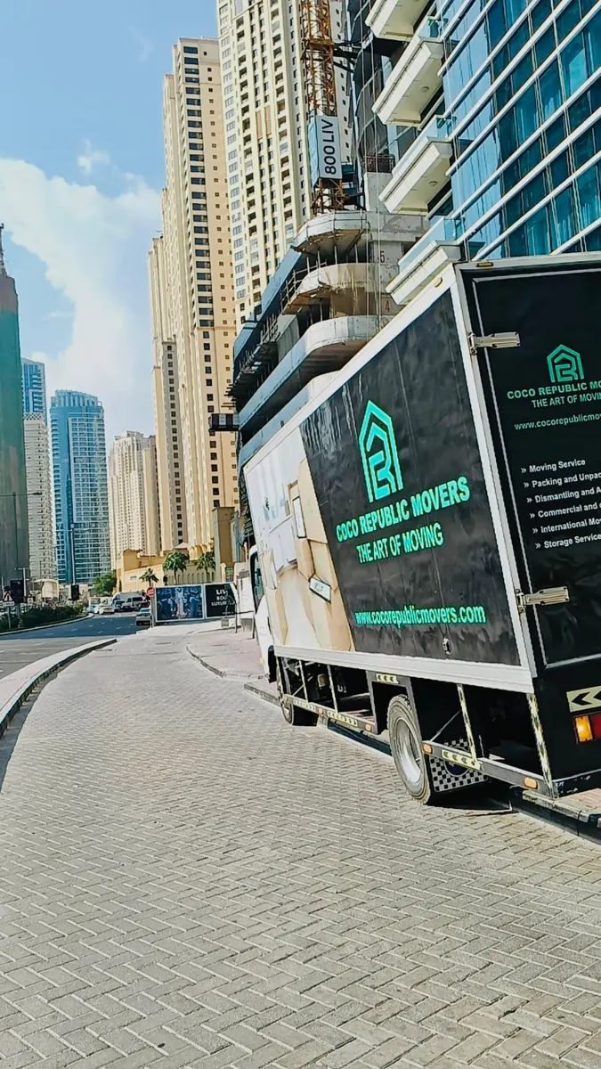 Moving truck parked beside residential towers in Dubai Marina